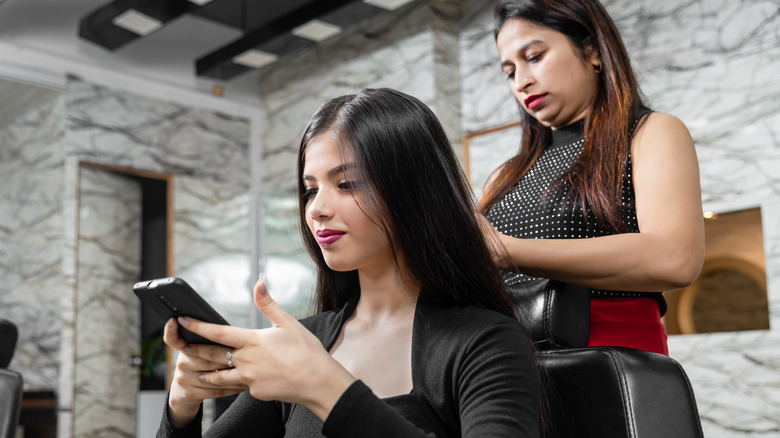 woman using phone at salon