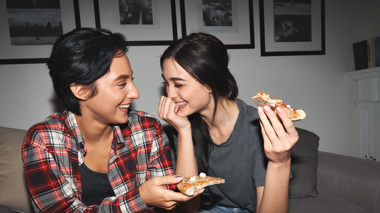 young lgbtq+ couple eating pizza