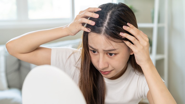 woman looking concerned at scalp