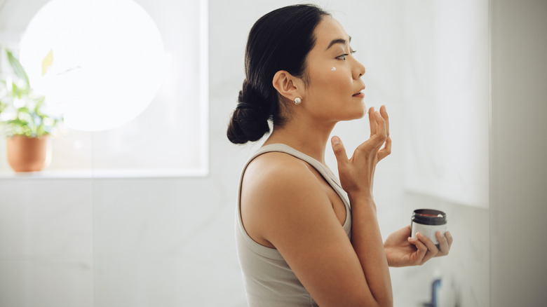 Woman using face moisturizer