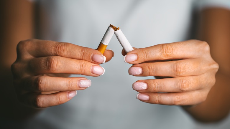 Woman holding broken cigarette