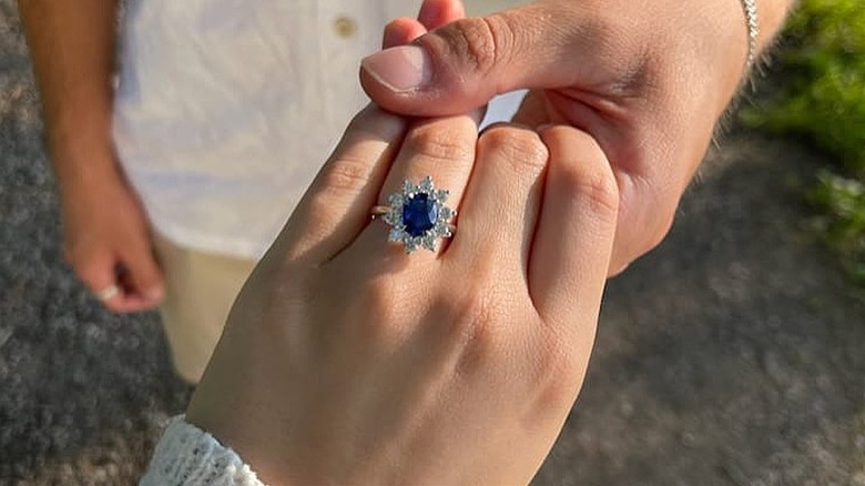 Hand displaying statement sapphire engagement ring 