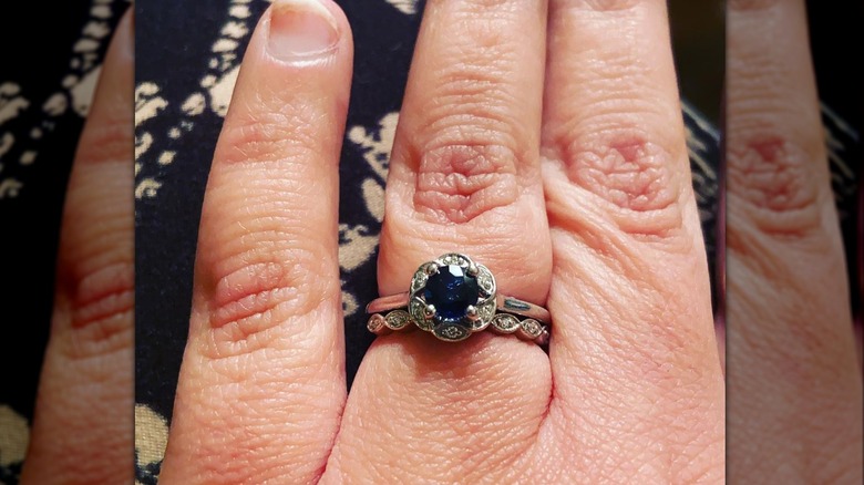 Hand displaying sapphire ring, vintage setting