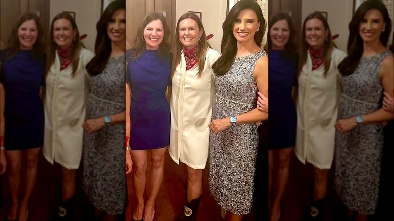 Sarah Huckabee Sanders posing with friends in a white shirt dress and red bandana.