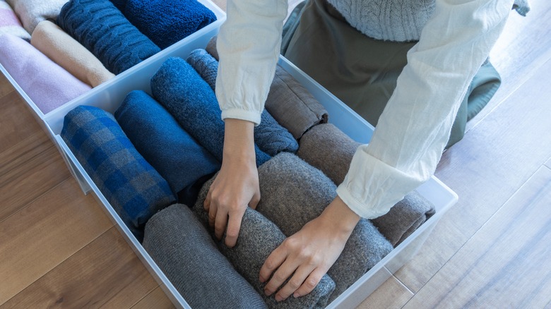 woman organizing clothes in boxes