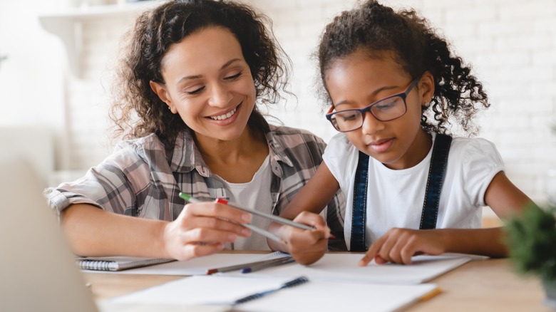 Woman drawing ideas with daughter
