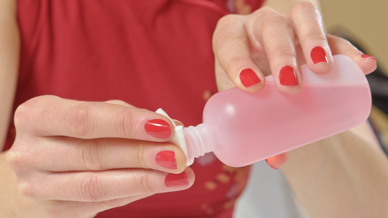 woman pouring nail polish remover