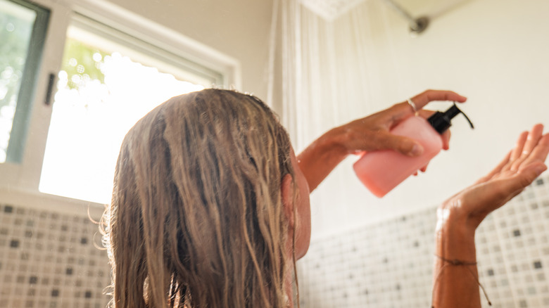 Woman using shampoo in shower