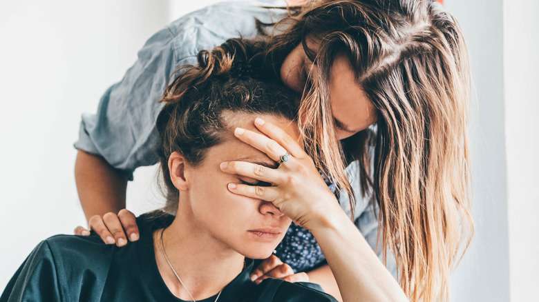 A woman leaning over her stressed partner.