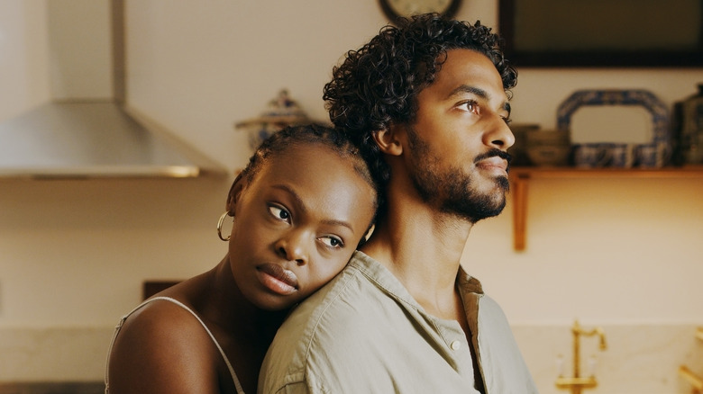 An unhappy couple hugging in the kitchen.