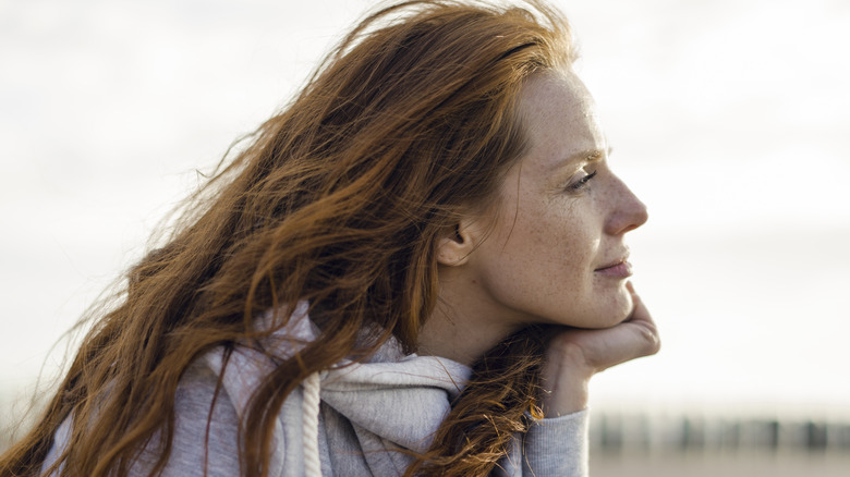 A woman daydreaming by the ocean.