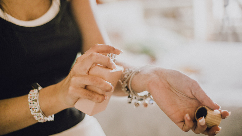 Woman spraying perfume on wrist