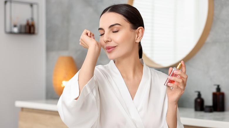 Smiling woman smelling fragrance