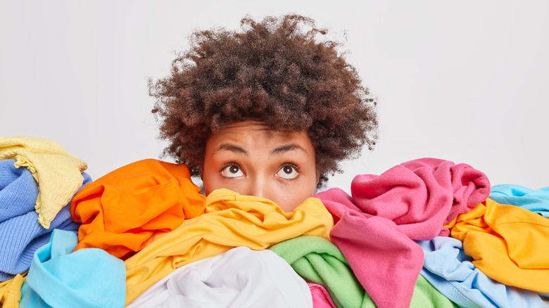 Woman in clutter of clothes