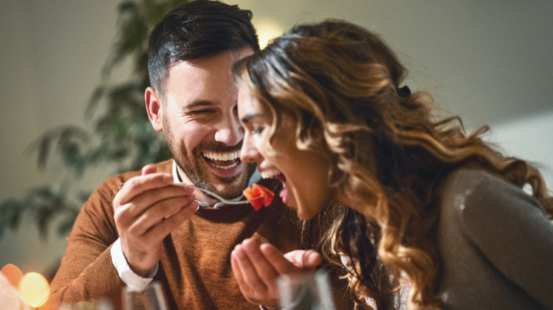 Man feeding woman at restaurant