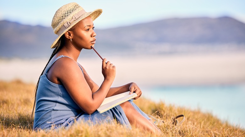 Woman sitting on grass and journaling