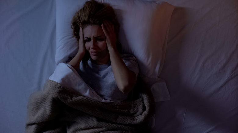 woman with headache in bed
