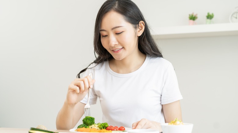 smiling woman eating vegetables