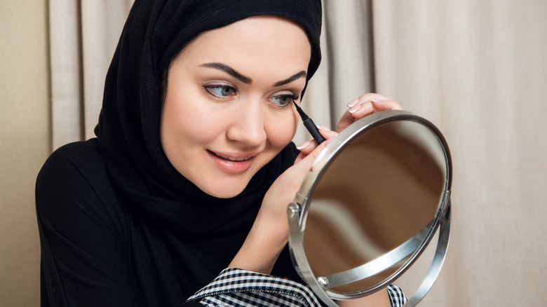 Woman applying eyeliner