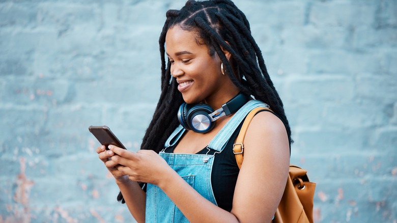 Woman smiles at cell phone