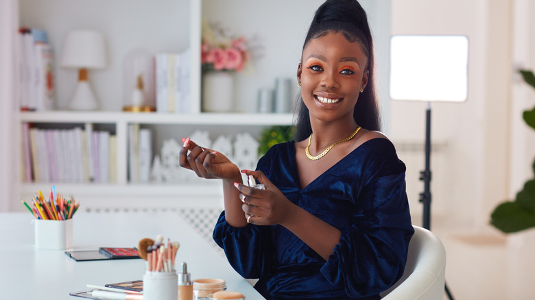 Woman applies perfume 