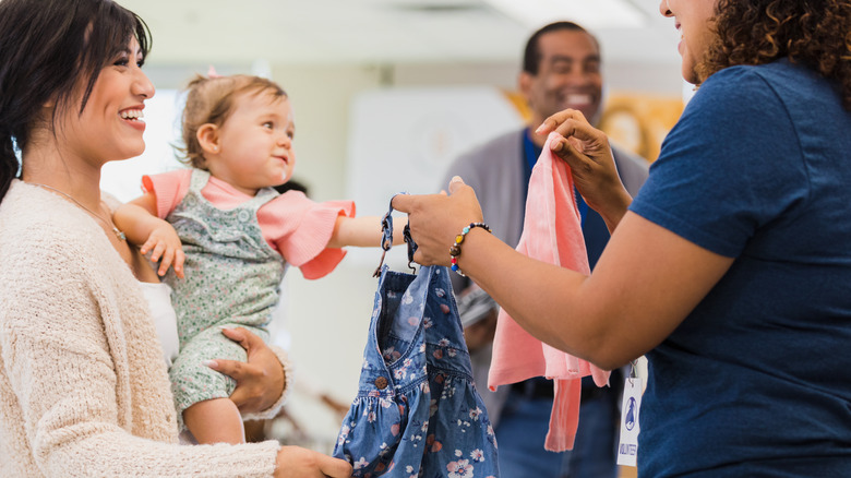 Woman accepting donated baby clothes