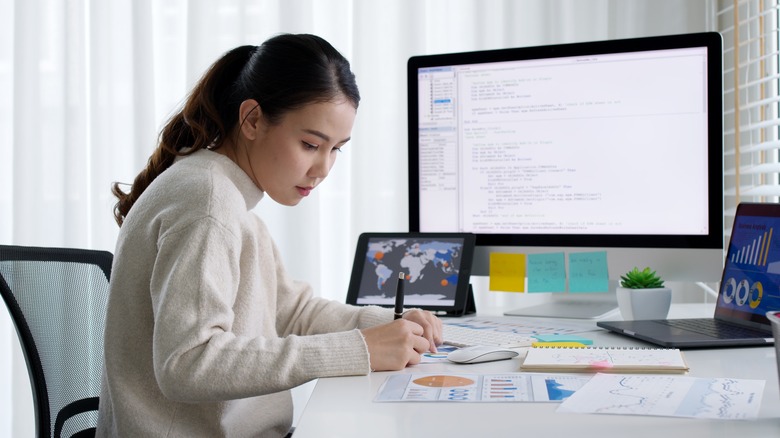 Woman writing at work desk