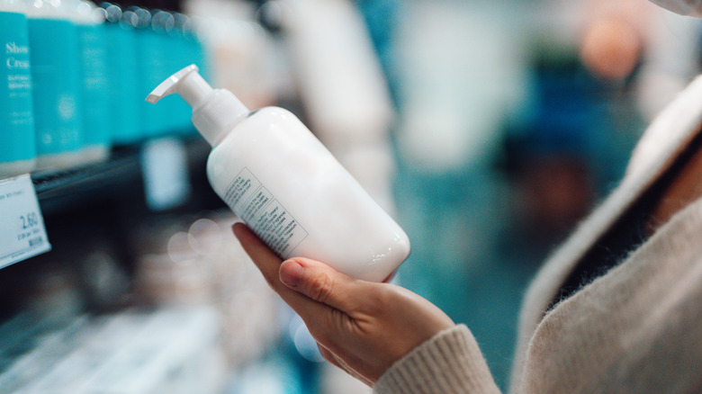 Someone analyzing a shampoo product in the grocery store