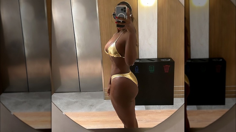 Woman wearing gold bikini in selfie mirror