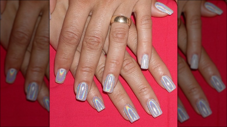 hand with rainbow holographic white shimmer nails