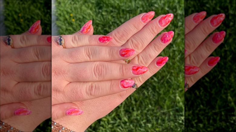 hand with pink marbled short stiletto nails