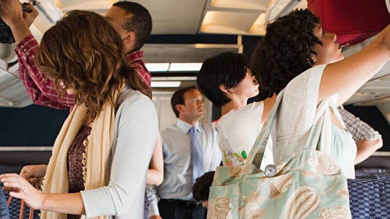 people on airplane loading luggage