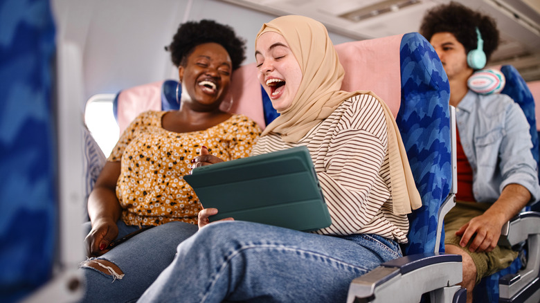 two women laughing on airplane