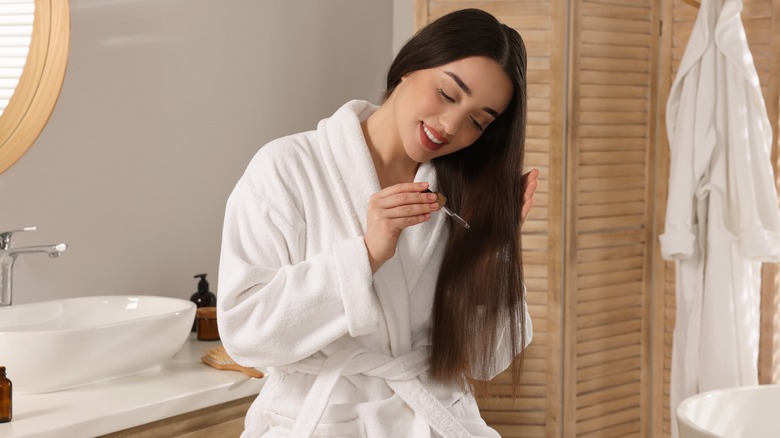 woman applying clove oil to hair