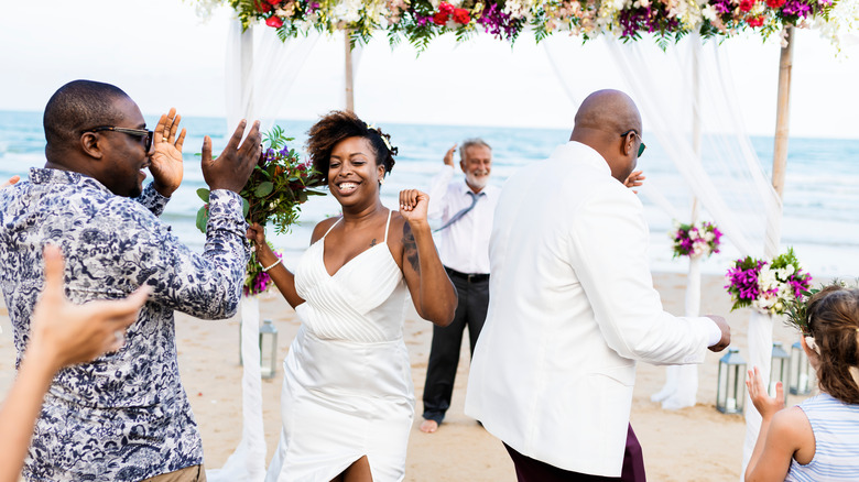 Black couple dancing at beach wedding