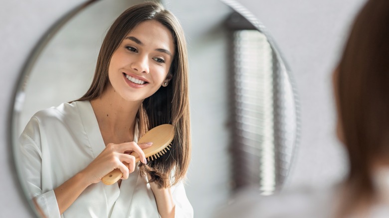 woman combing hair in mirror