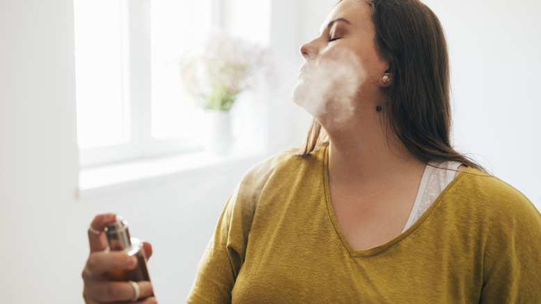 Woman spraying perfume