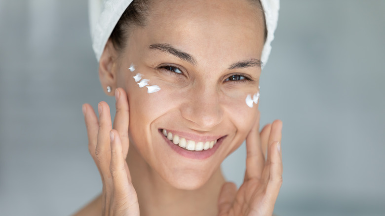 Woman applying eye cream 