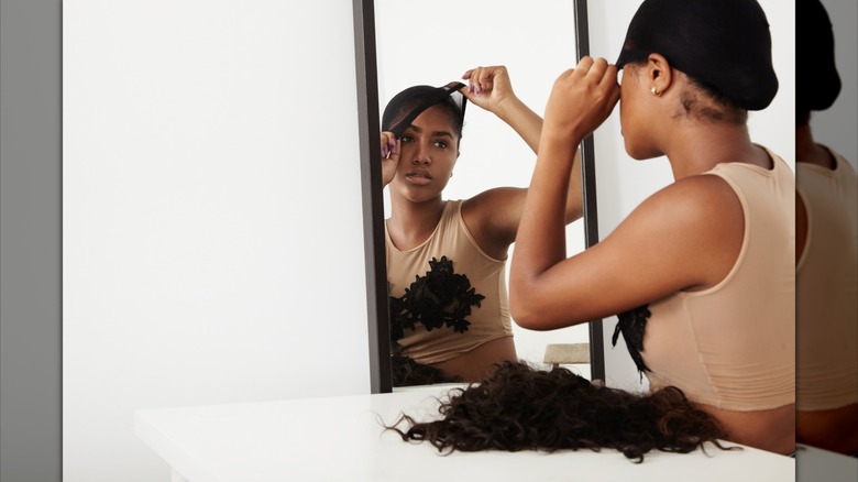 Woman fitting wig in mirror