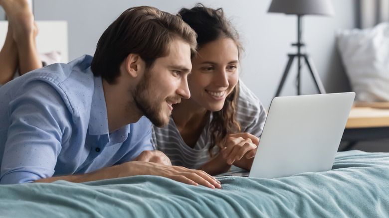 a couple in bed shopping online