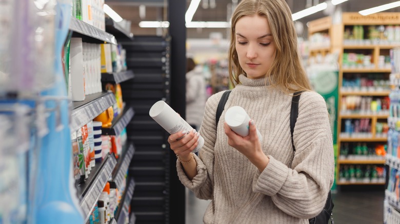 Woman choosing hair product at store