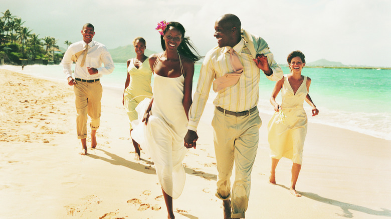 newlyweds and friends on beach