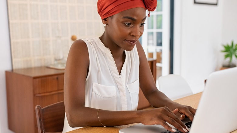 Black woman typing on laptop