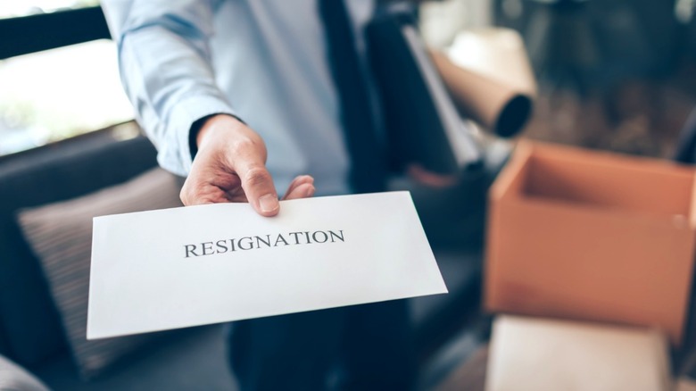 Businessman handing in resignation letter