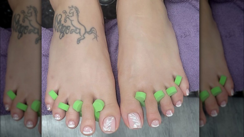 French pedicure with floral design and glitter 
