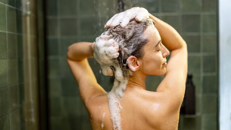 young woman showering and washing hair