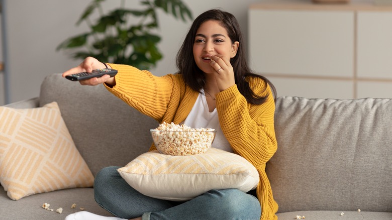 woman watching TV with snacks