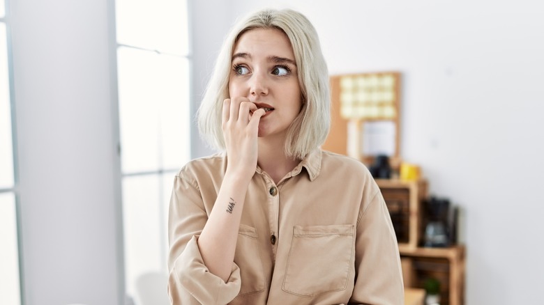 anxious woman biting fingernails