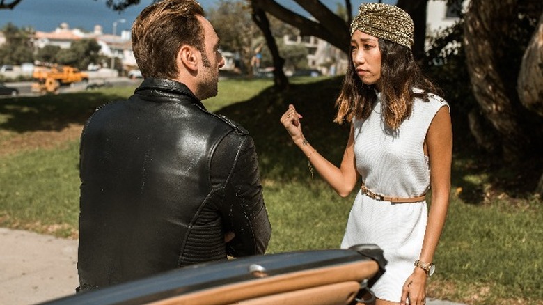 couple fighting by a car