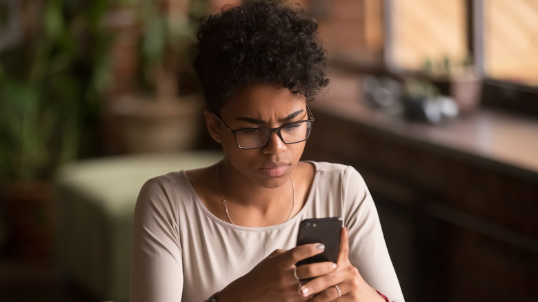 Woman stressed on phone looking at updates